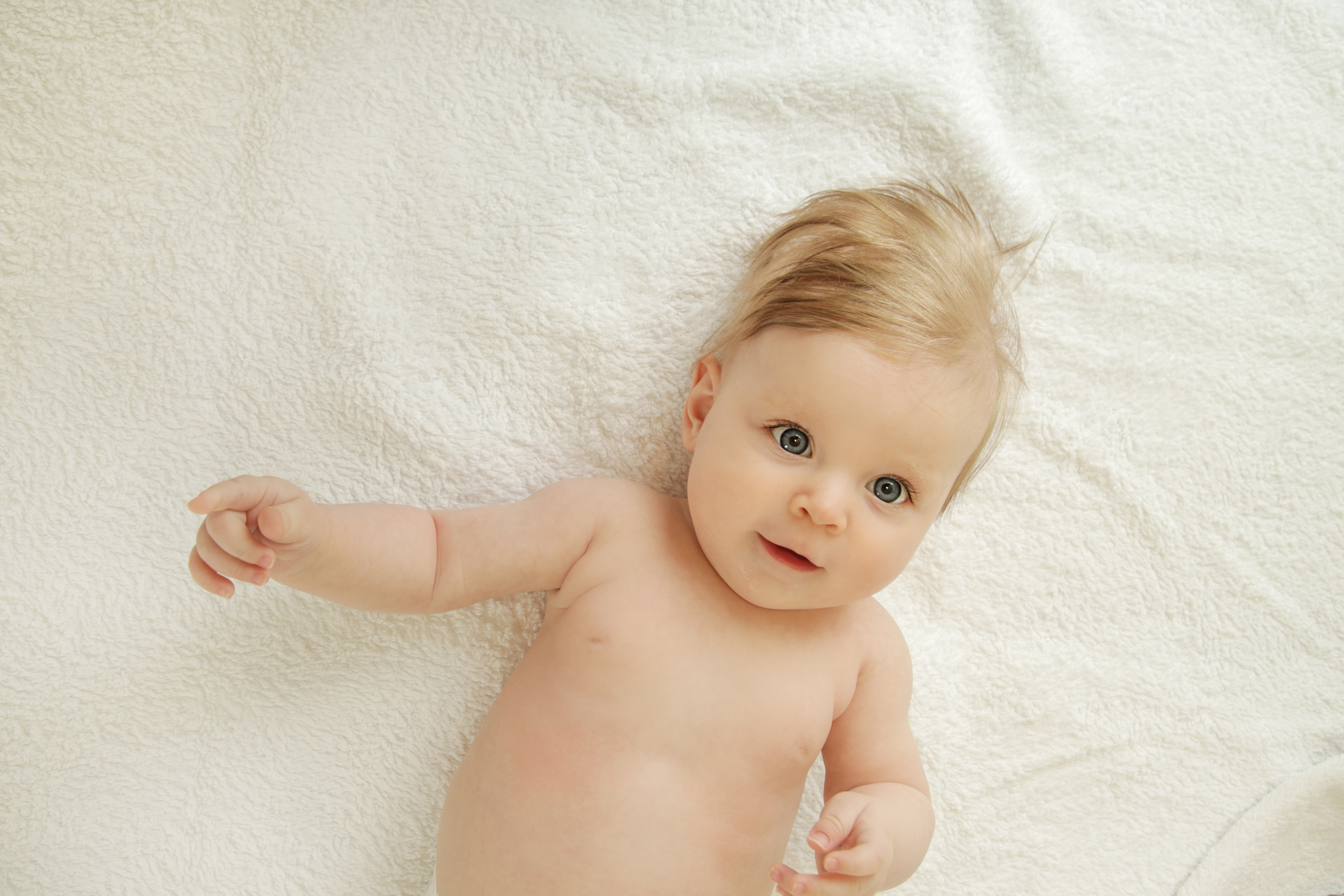 Portrait of five months old baby Afbeelding van een baby die op bed ligt