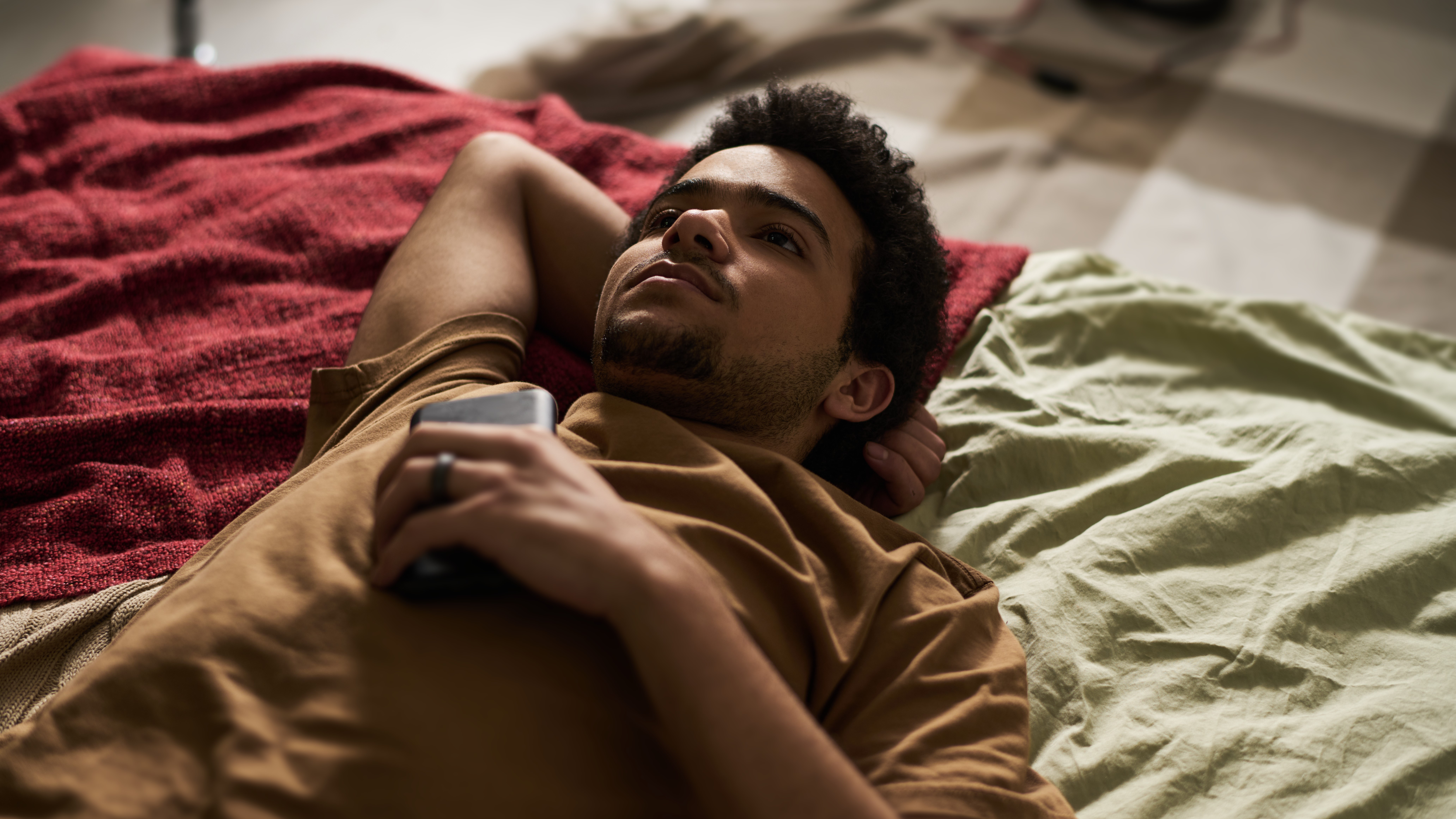 Jongen op bed met telefoon