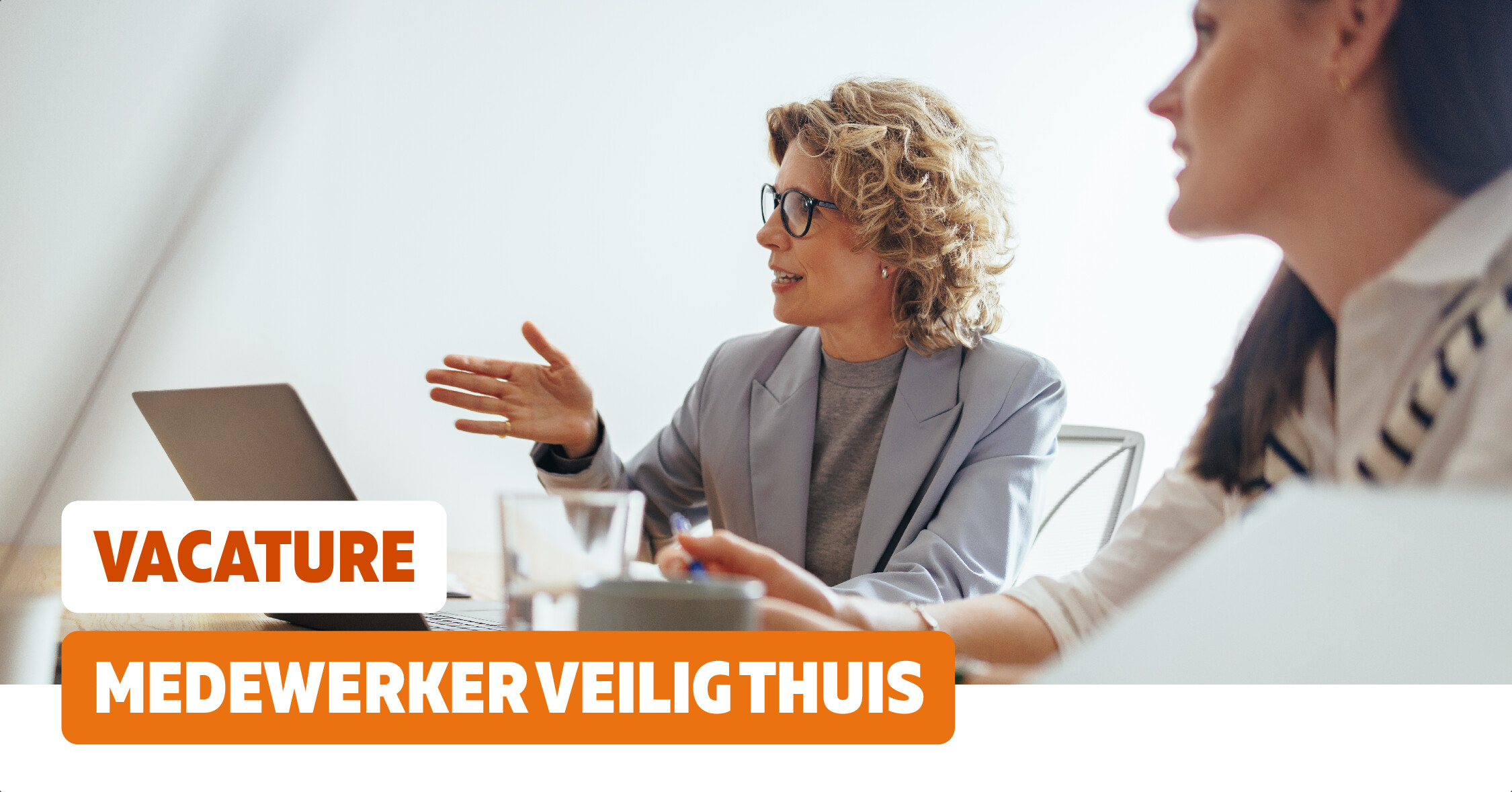 Twee vrouwen in overleg met laptop. Tekstuele aanvulling: vacature medewerker veilig thuis