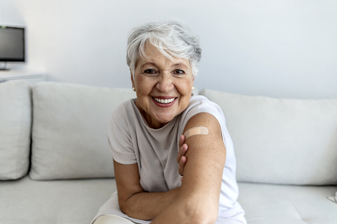 Portrait of a senior woman proudly showing her arm with bandage after getting vaccine. Portrait of a senior woman proudly showing her arm with bandage after getting vaccine.